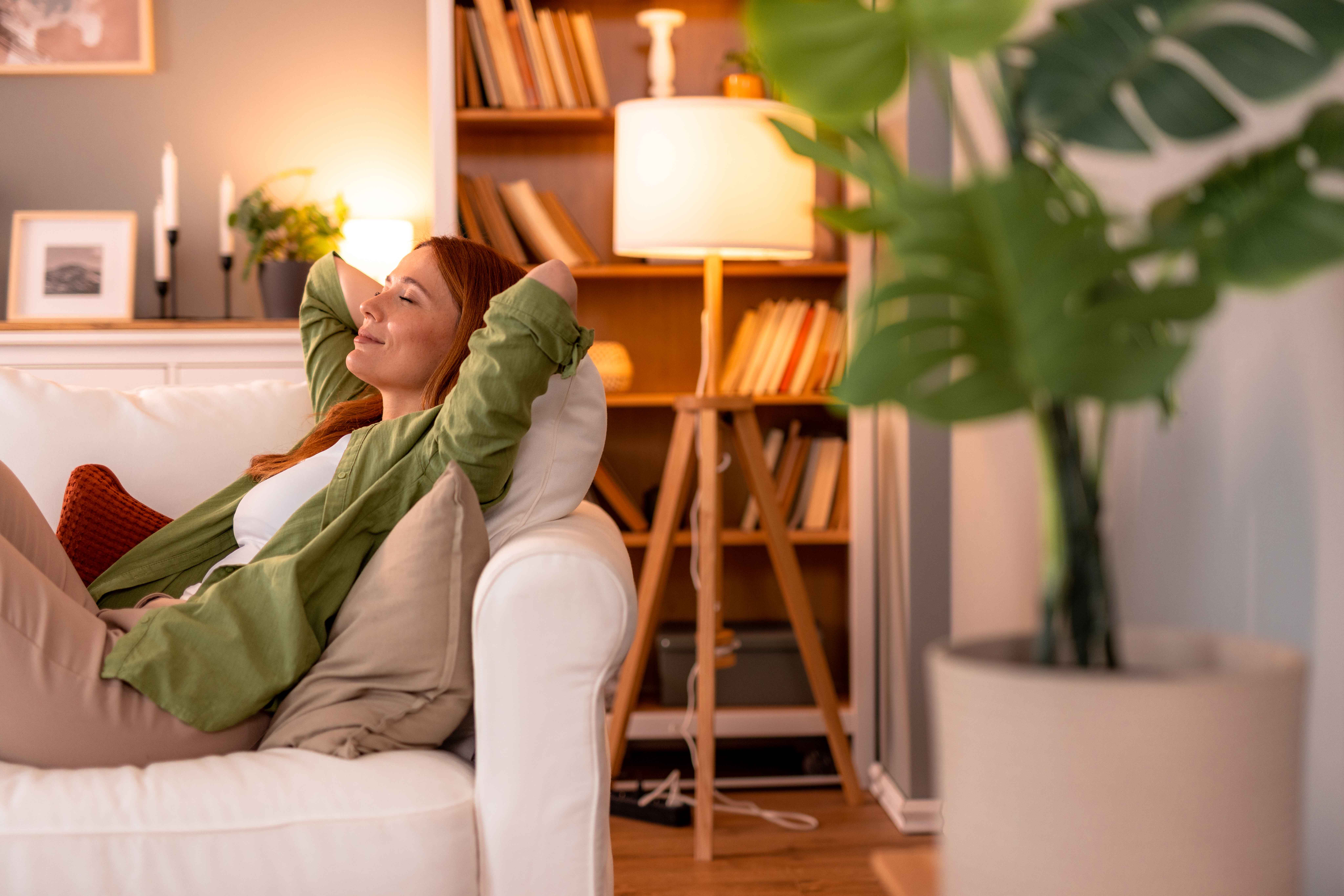 A woman relaxing on their couch in a cozy living room